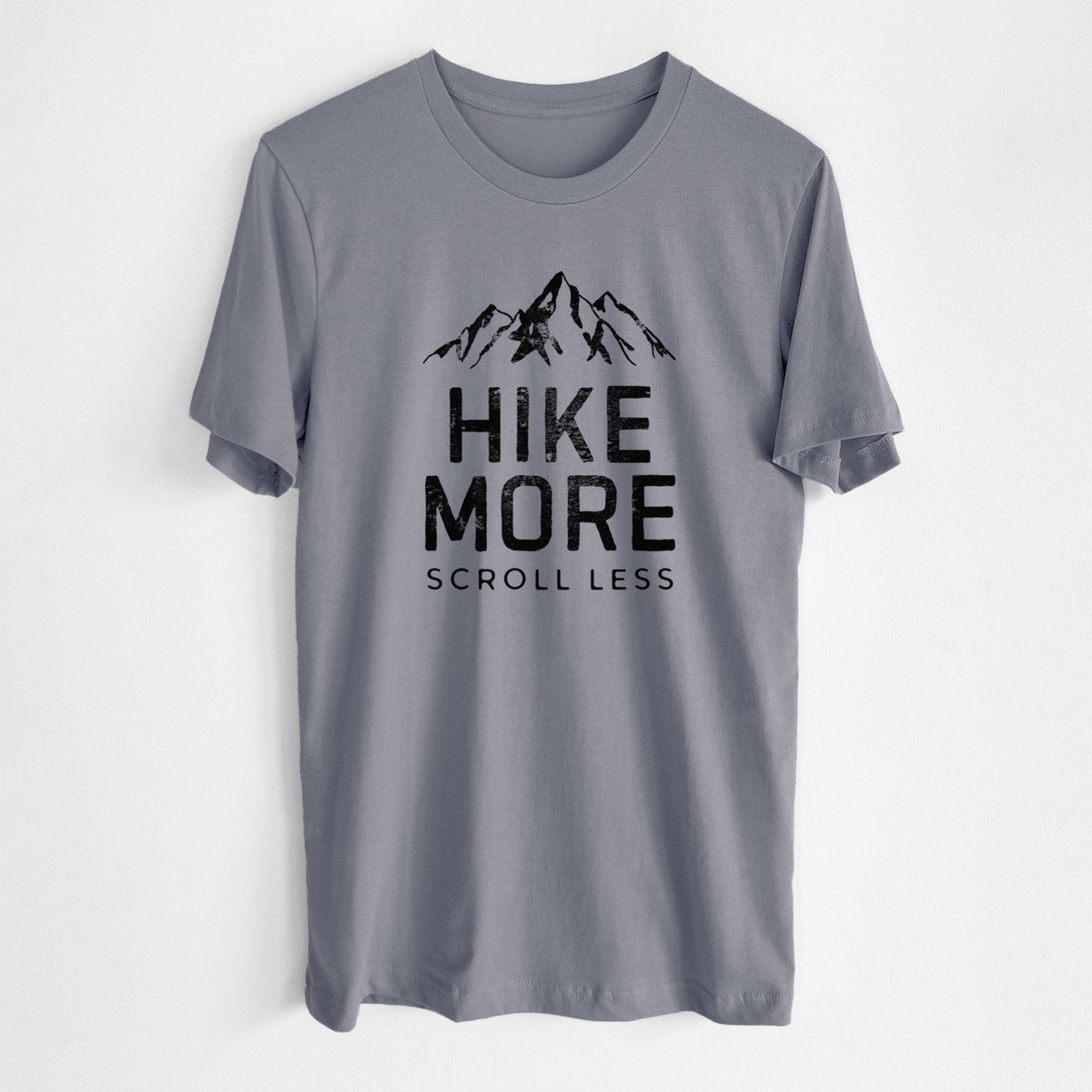Storm grey lightweight cotton t-shirt laid flat, printed with black mountain peaks above the bold words Hike More, Scroll Less.