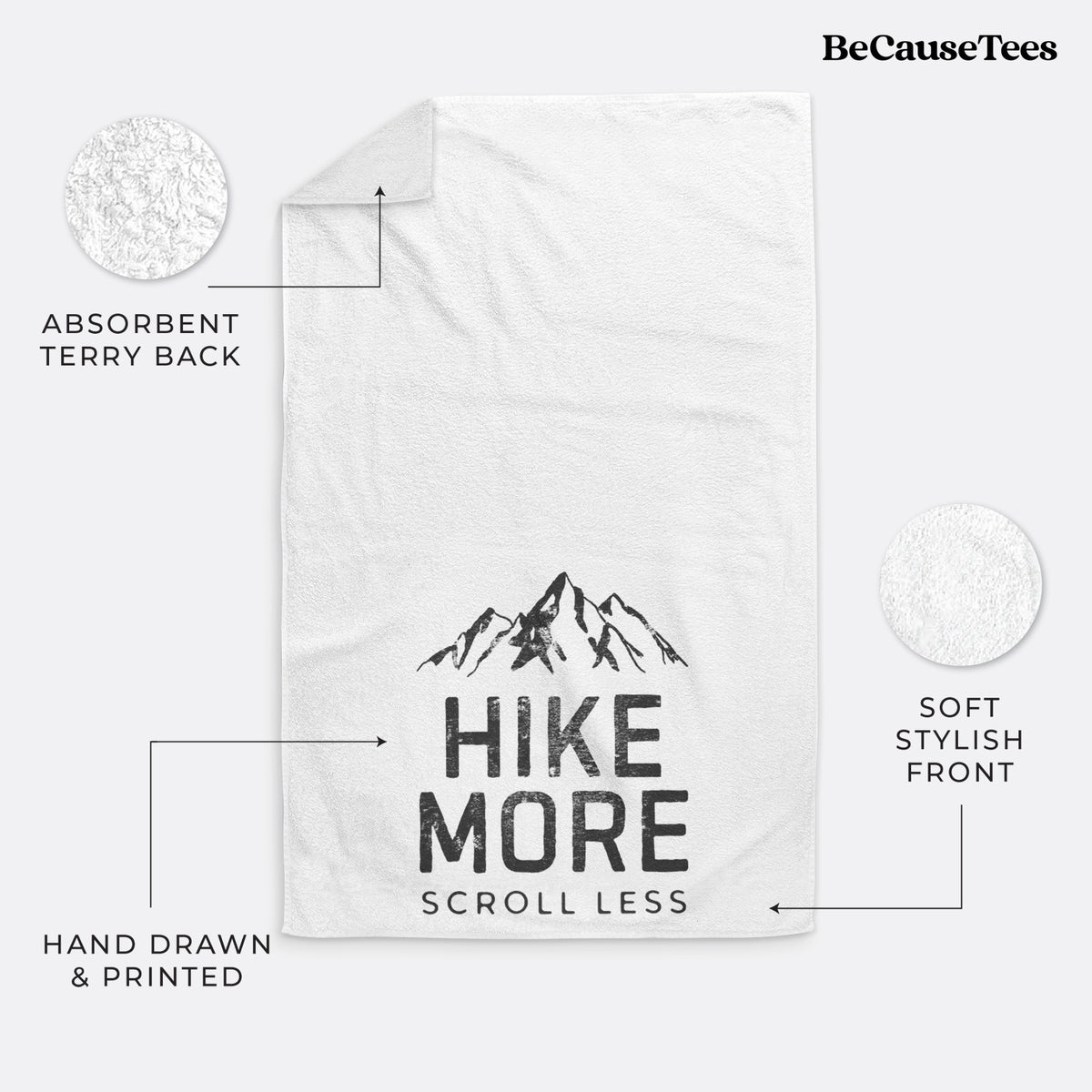 White hand towel printed with black mountain peaks above the bold words Hike More, Scroll Less.