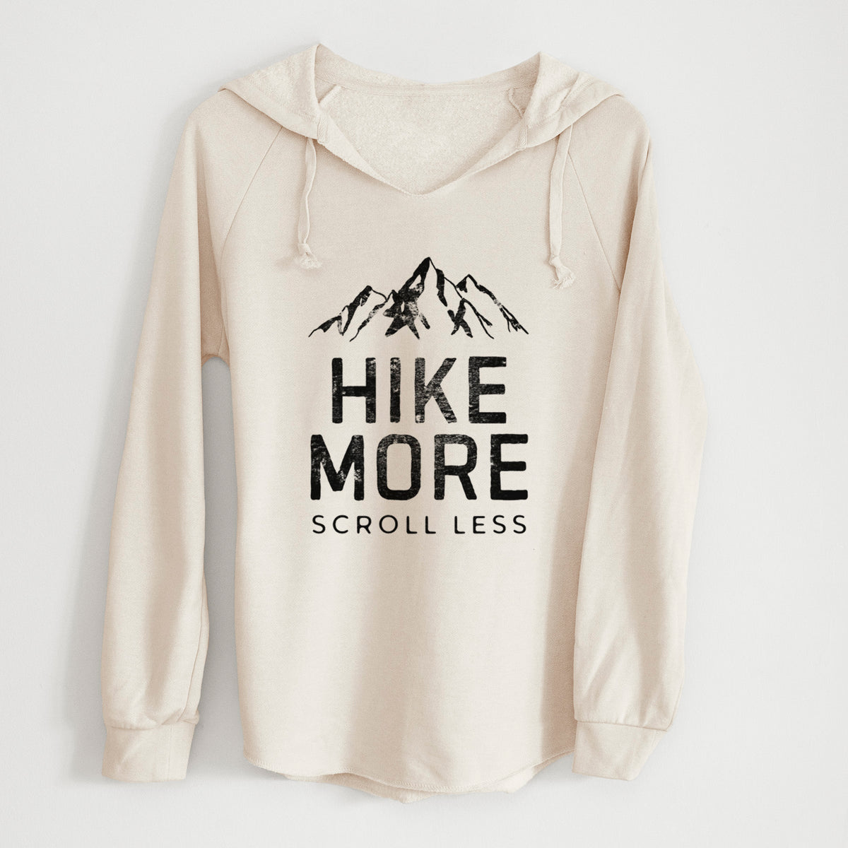 Bone cream women's Cali Wave hooded sweatshirt laid flat, printed with black mountain peaks above the bold words Hike More, Scroll Less.