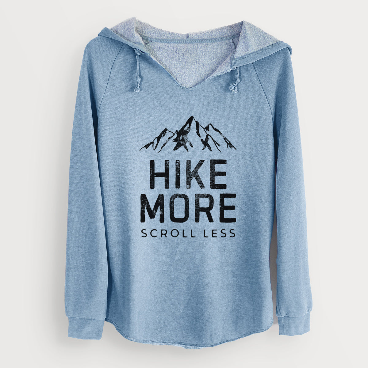 Misty blue women's Cali Wave hooded sweatshirt laid flat, printed with black mountain peaks above the bold words Hike More, Scroll Less.