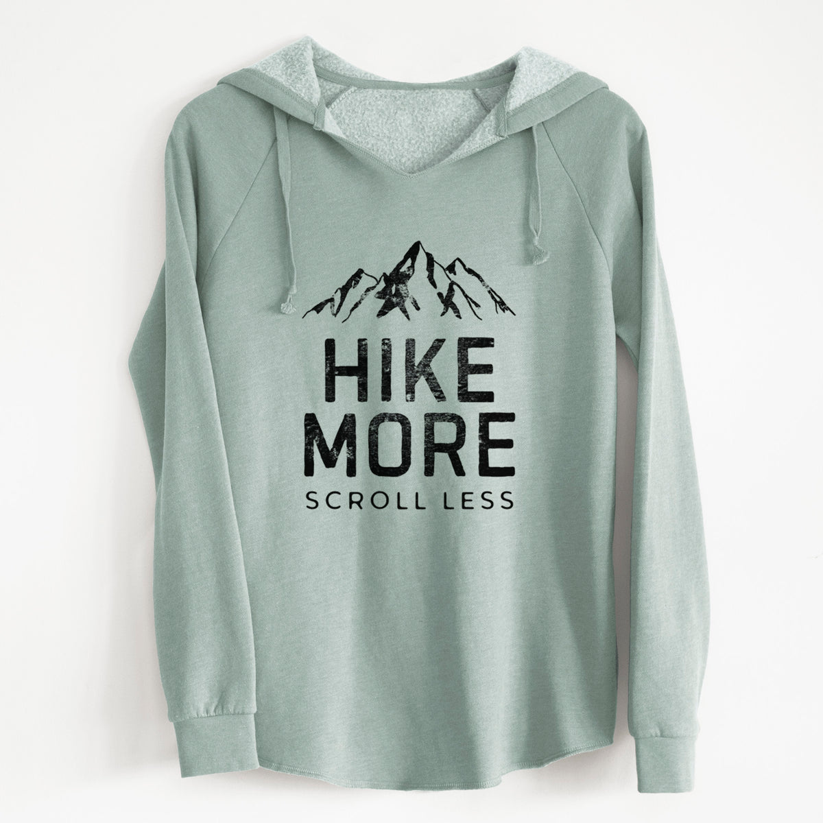 Sage green women's Cali Wave hooded sweatshirt laid flat, printed with black mountain peaks above the bold words Hike More, Scroll Less.