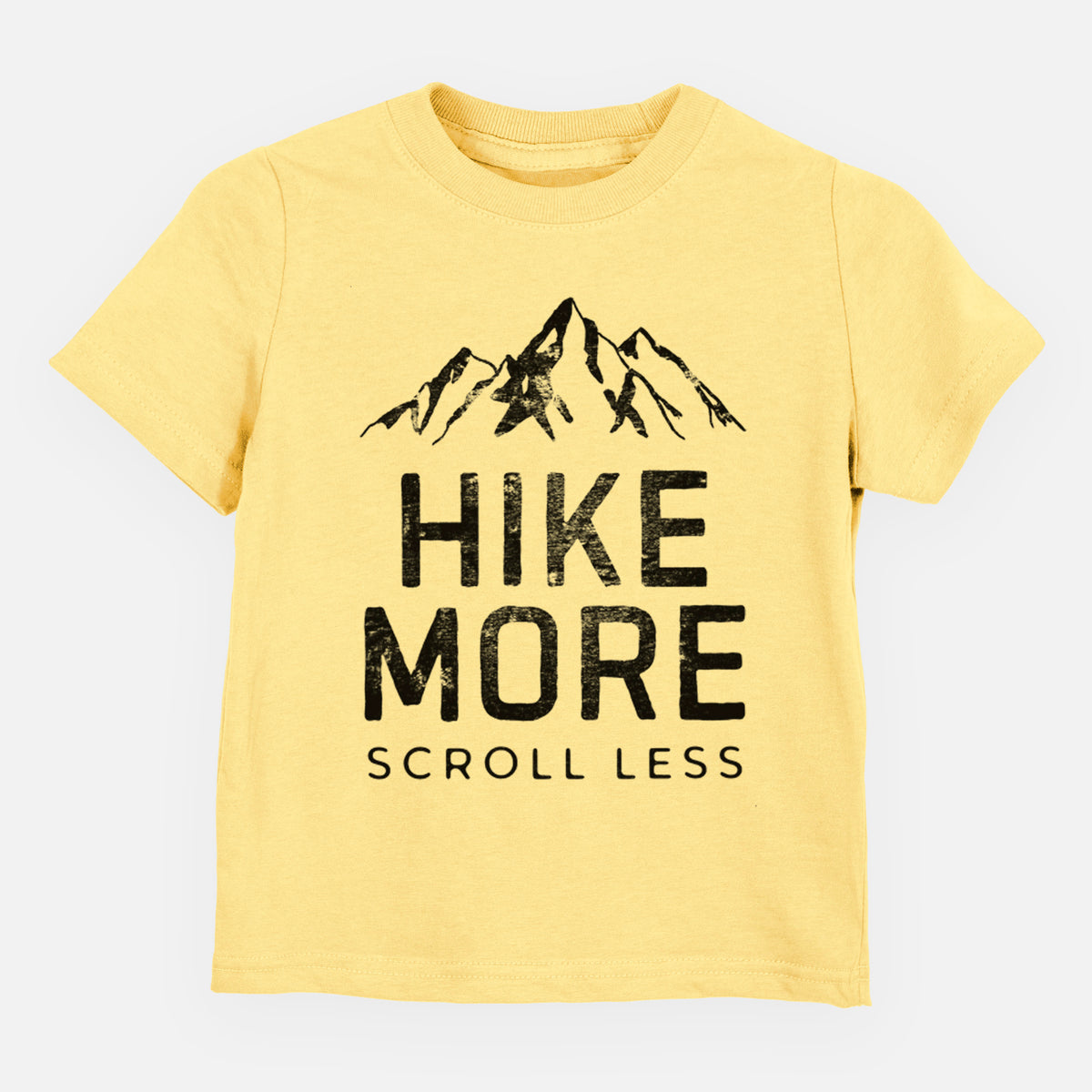 Butter yellow toddler t-shirt laid flat, printed with black mountain peaks above the bold words Hike More, Scroll Less.