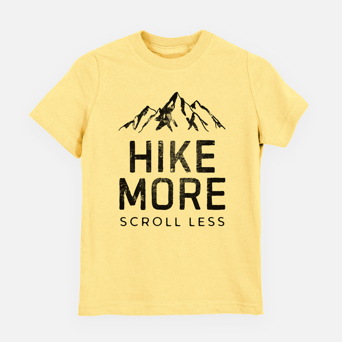 Butter yellow youth t-shirt laid flat, printed with black mountain peaks above the bold words Hike More, Scroll Less.