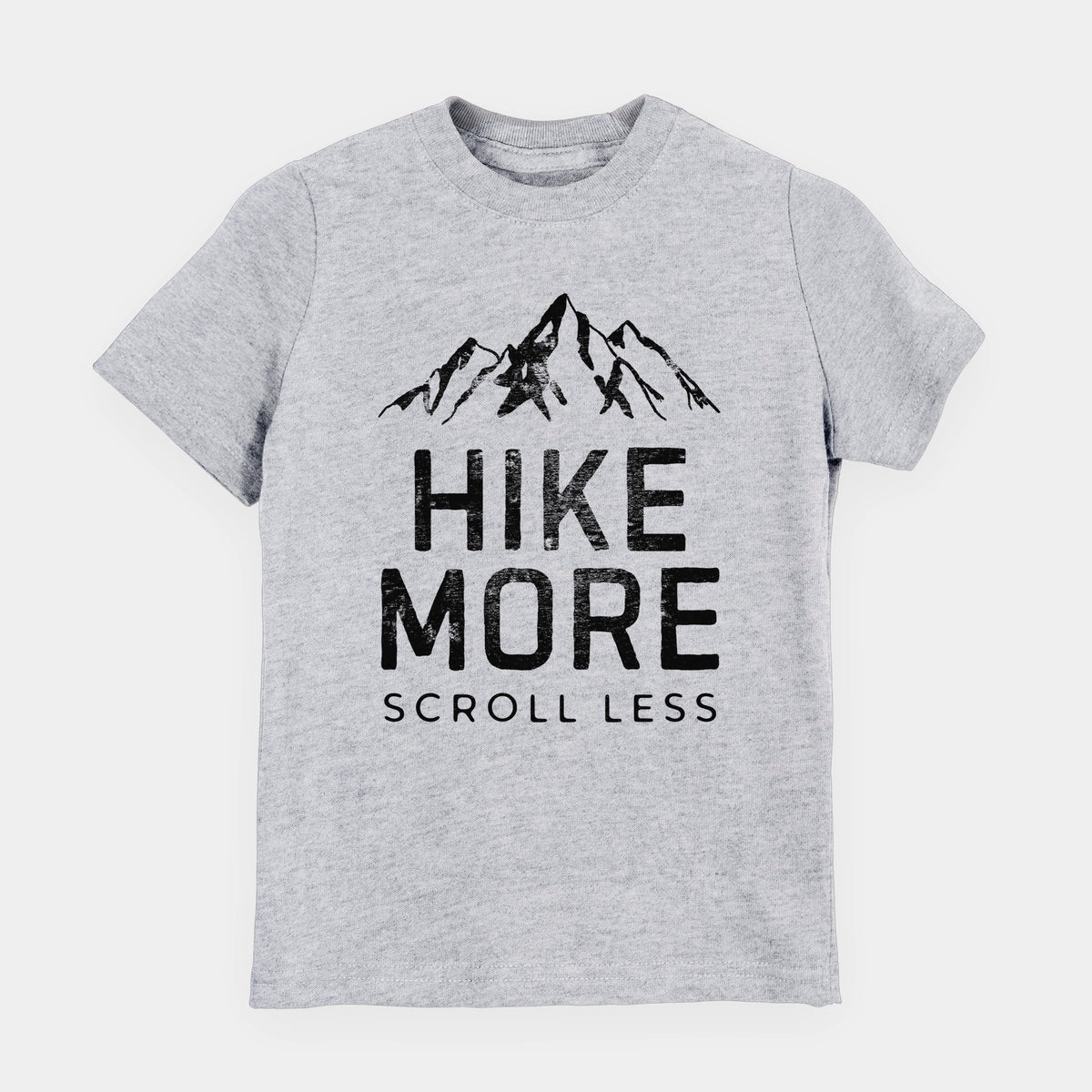 Heather grey youth t-shirt laid flat, printed with black mountain peaks above the bold words Hike More, Scroll Less.