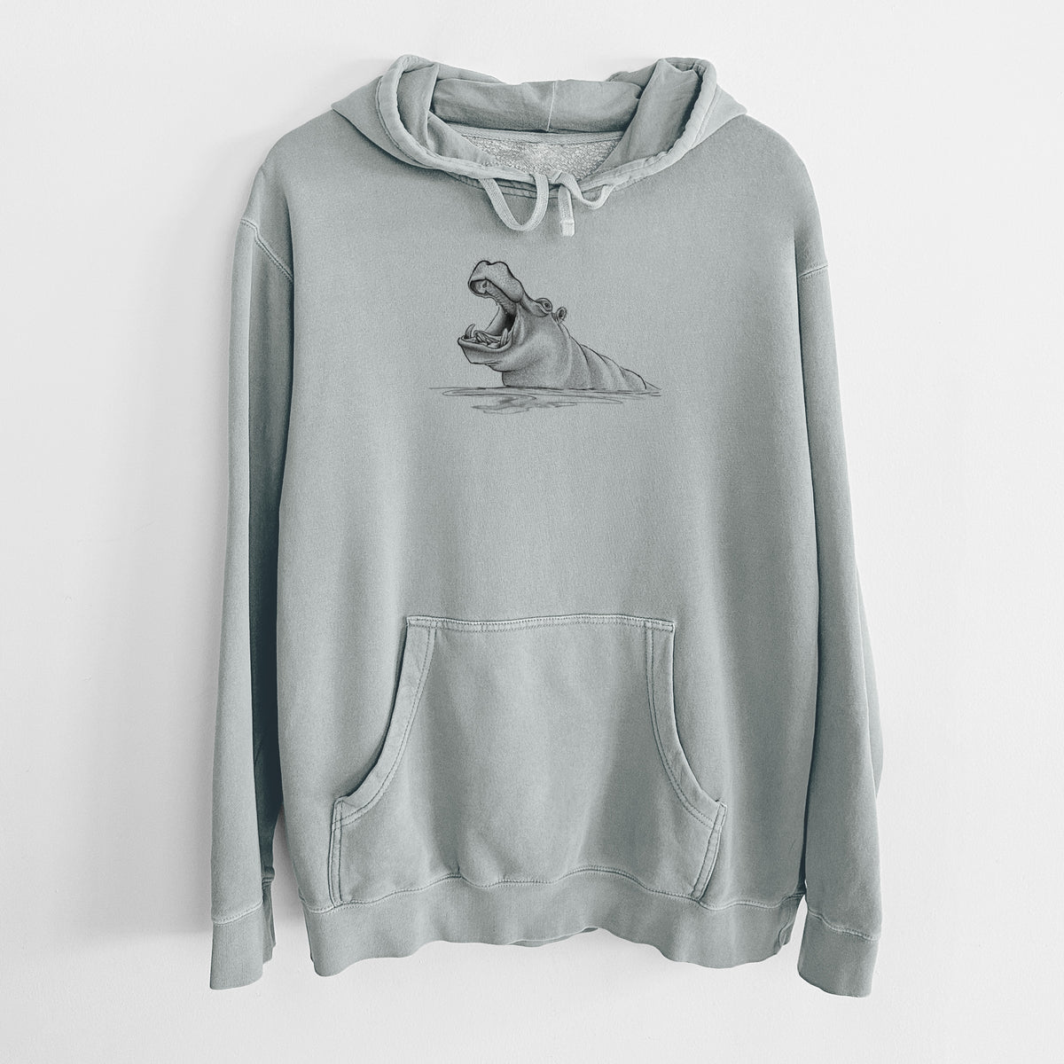 Sage green pigment dyed hoodie laid flat, printed with a black ink illustration of a hippo yawning with its mouth wide open, half submerged in water.