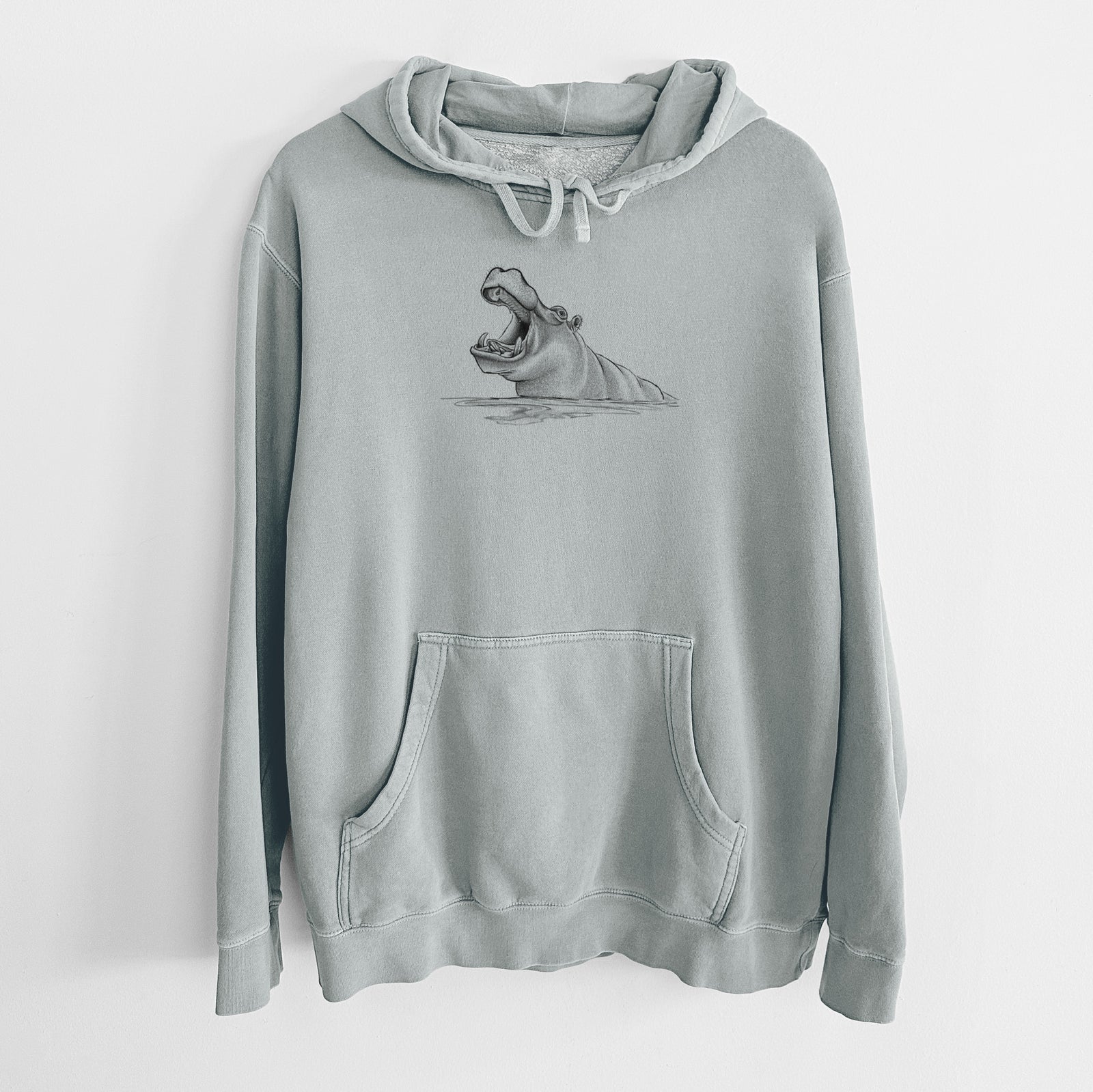 Sage green pigment dyed hoodie laid flat, printed with a black ink illustration of a hippo yawning with its mouth wide open, half submerged in water.