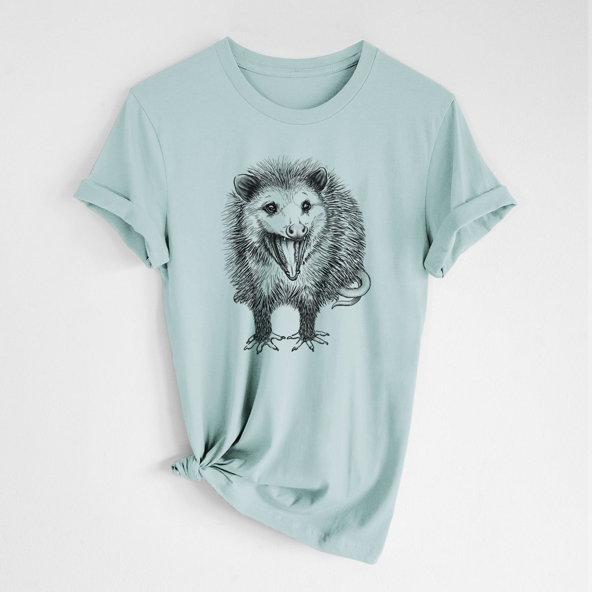 Dusty blue lightweight cotton t-shirt laid flat with the sleeves rolled, printed with a detailed black ink illustration of an opossum standing and facing forward, mouth open wide in a hiss, with shaggy fur and its tail curled behind.