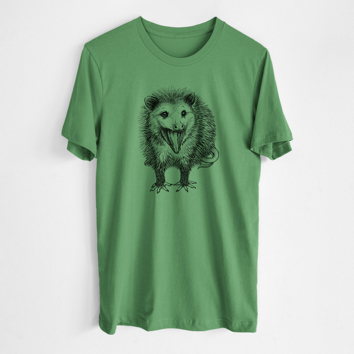 Leaf green lightweight cotton t-shirt laid flat, printed with a detailed black ink illustration of an opossum standing and facing forward, mouth open wide in a hiss, with shaggy fur and its tail curled behind.