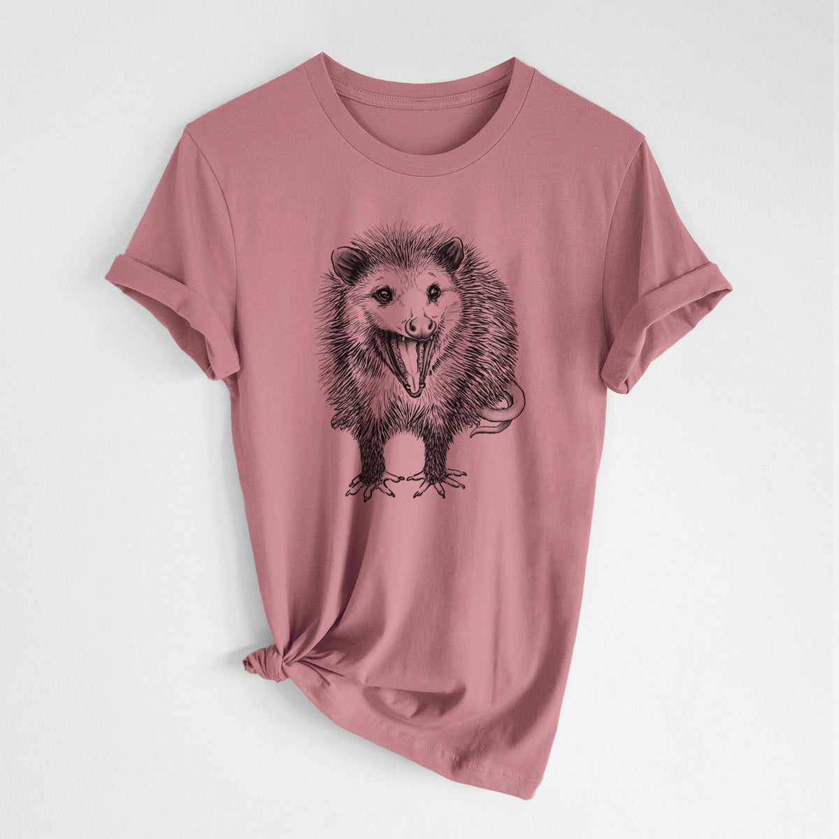 Mauve pink lightweight cotton t-shirt laid flat with the sleeves rolled, printed with a detailed black ink illustration of an opossum standing and facing forward, mouth open wide in a hiss, with shaggy fur and its tail curled behind.