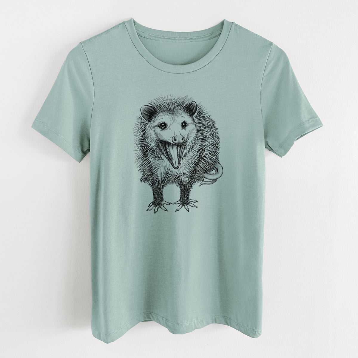 Dusty blue women's relaxed fit cotton t-shirt laid flat, printed with a detailed black ink illustration of an opossum standing and facing forward, mouth open wide in a hiss, with shaggy fur and its tail curled behind.