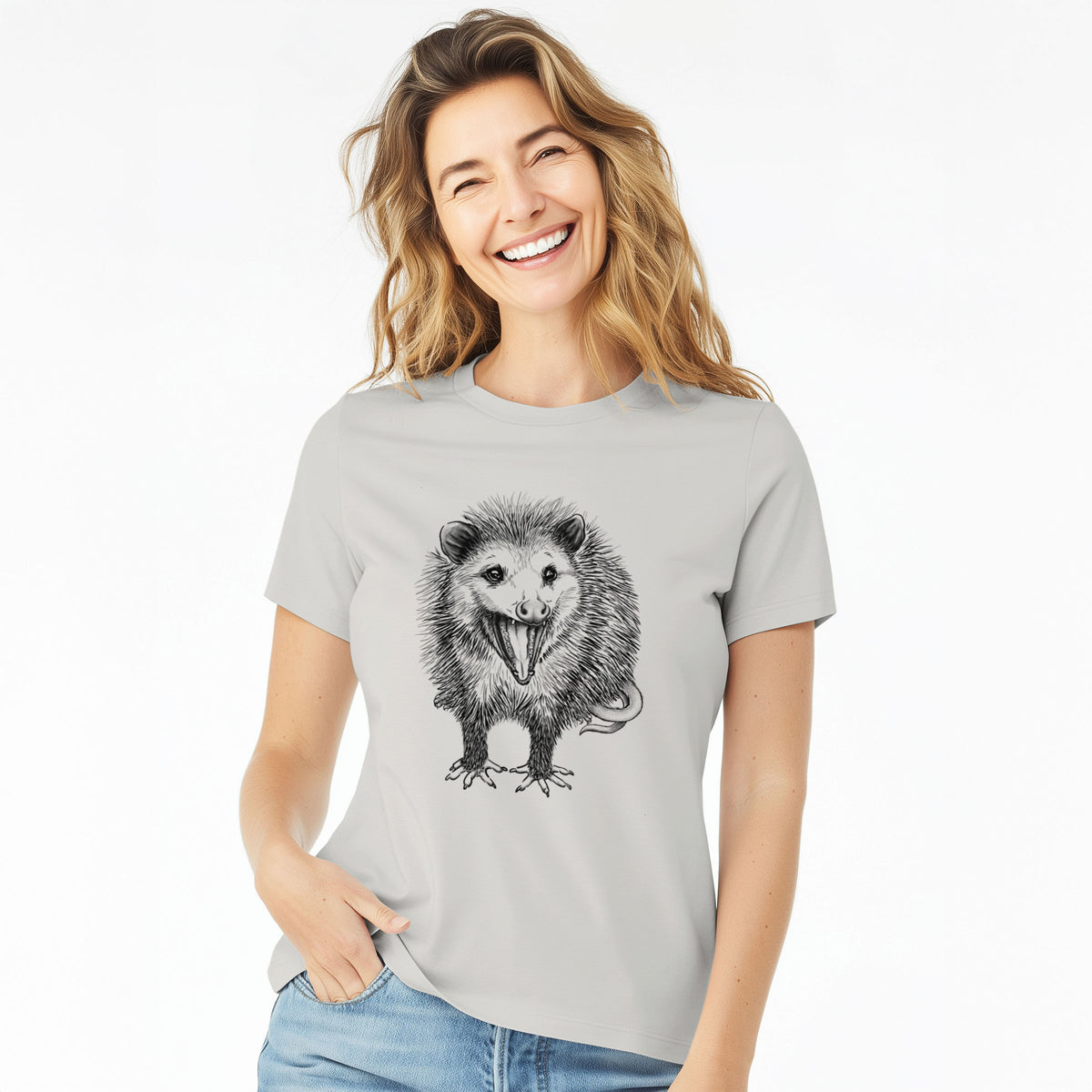 Woman wearing a lunar grey women's relaxed fit cotton t-shirt printed with a detailed black ink illustration of an opossum standing and facing forward, mouth open wide in a hiss, with shaggy fur and its tail curled behind.
