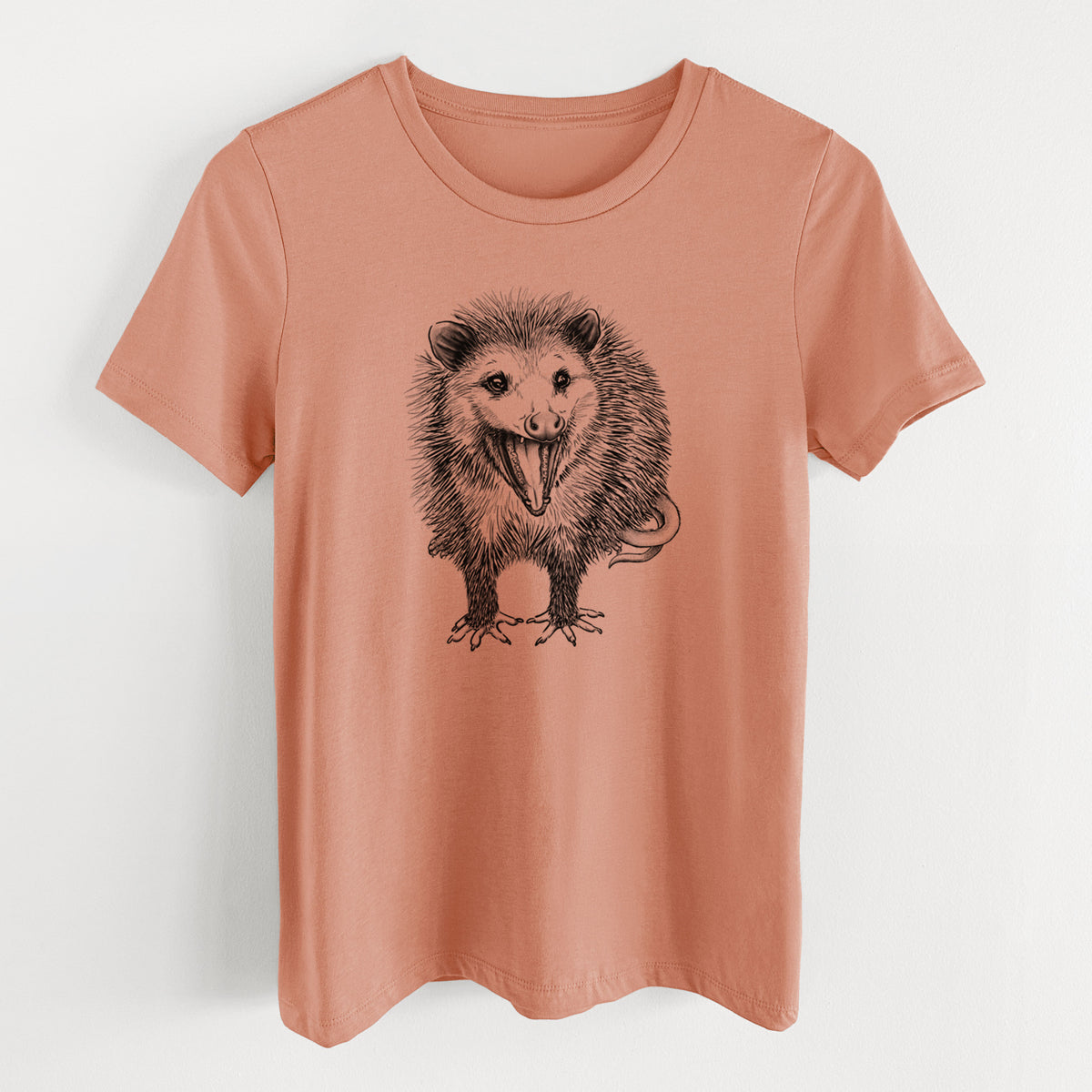Terracotta orange women's relaxed fit cotton t-shirt laid flat, printed with a detailed black ink illustration of an opossum standing and facing forward, mouth open wide in a hiss, with shaggy fur and its tail curled behind.