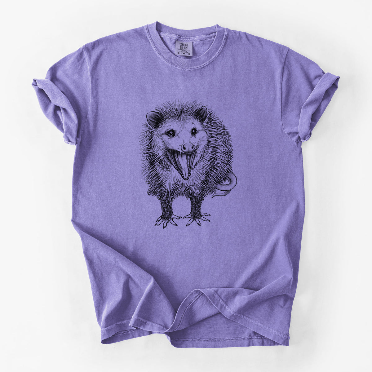 Violet purple Comfort Colors t-shirt laid flat, printed with a detailed black ink illustration of an opossum standing and facing forward, mouth open wide in a hiss, with shaggy fur and its tail curled behind.