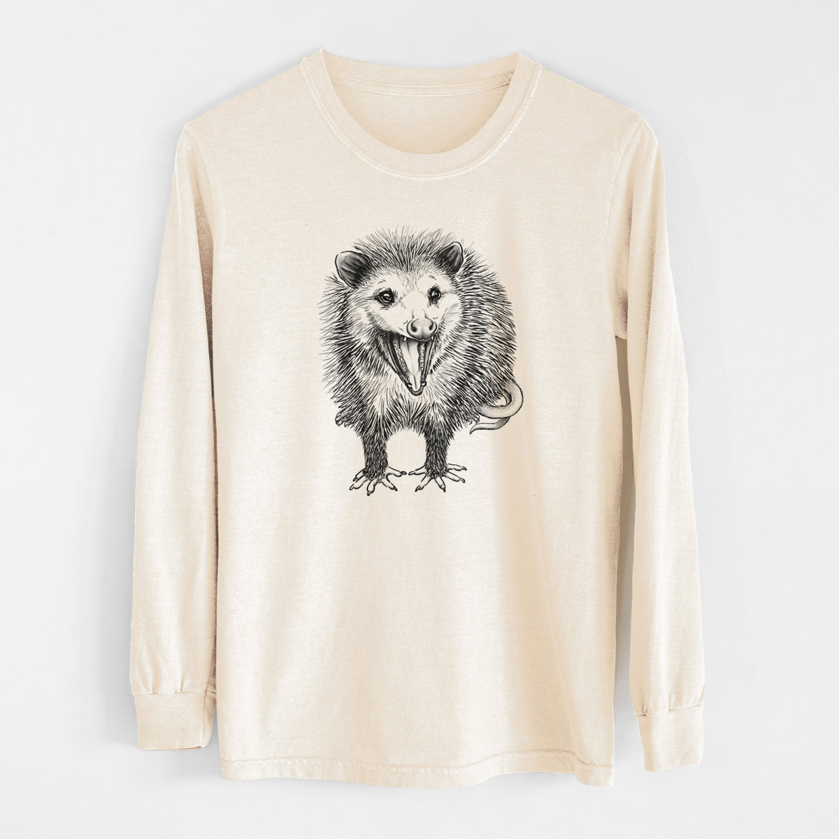Ivory Comfort Colors long sleeve shirt laid flat, printed with a detailed black ink illustration of an opossum standing and facing forward, mouth open wide in a hiss, with shaggy fur and its tail curled behind.