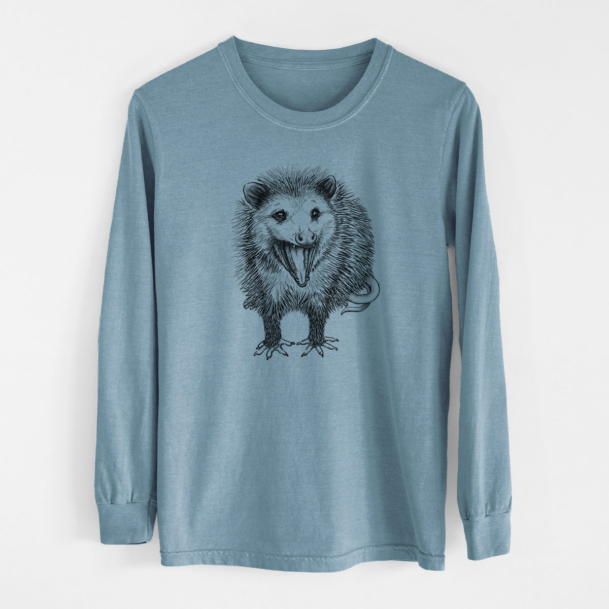 Steel blue Comfort Colors long sleeve shirt laid flat, printed with a detailed black ink illustration of an opossum standing and facing forward, mouth open wide in a hiss, with shaggy fur and its tail curled behind.