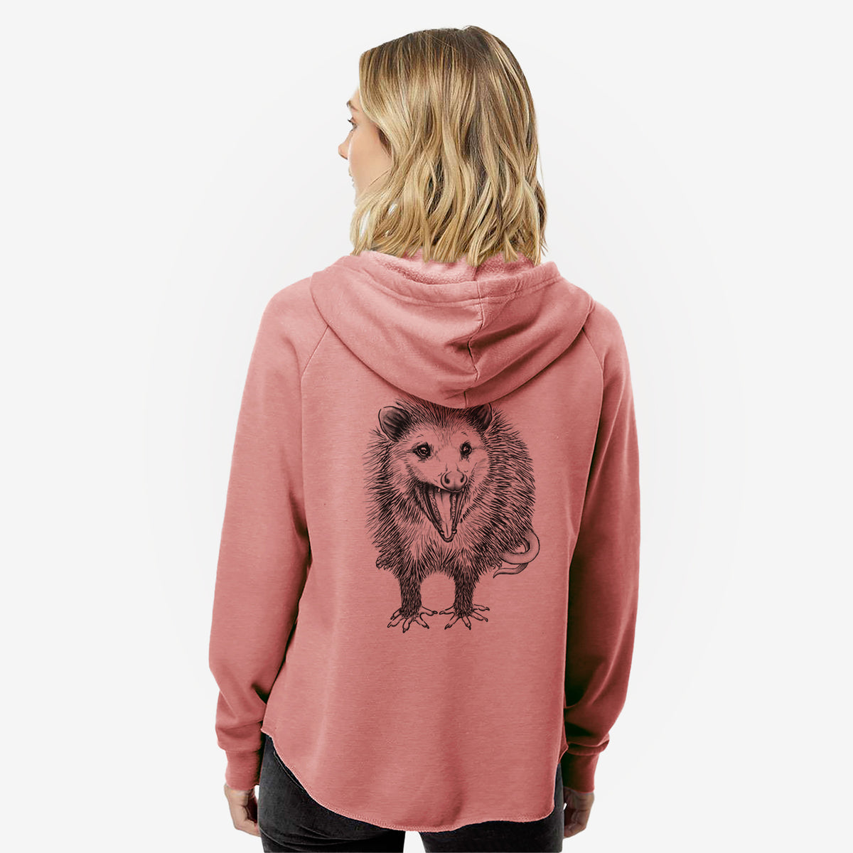 Woman wearing a dusty rose women's Cali Wave zip-up sweatshirt printed with a detailed black ink illustration of an opossum standing and facing forward, mouth open wide in a hiss, with shaggy fur and its tail curled behind, seen from behind.