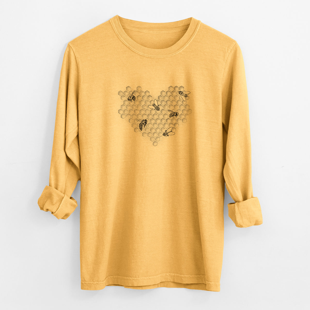 Golden wheat yellow Comfort Colors long sleeve shirt laid flat with the cuffs rolled, printed with a black ink heart made of honeycomb cells with small bees crawling across it.
