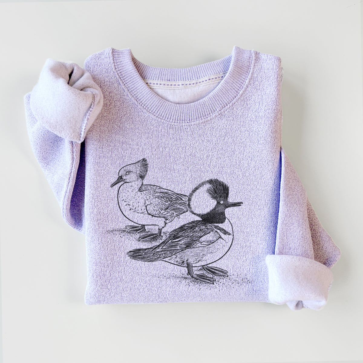 Ice purple knit sweatshirt printed with a detailed black ink illustration of a pair of hooded mergansers, male and female, styled flat.