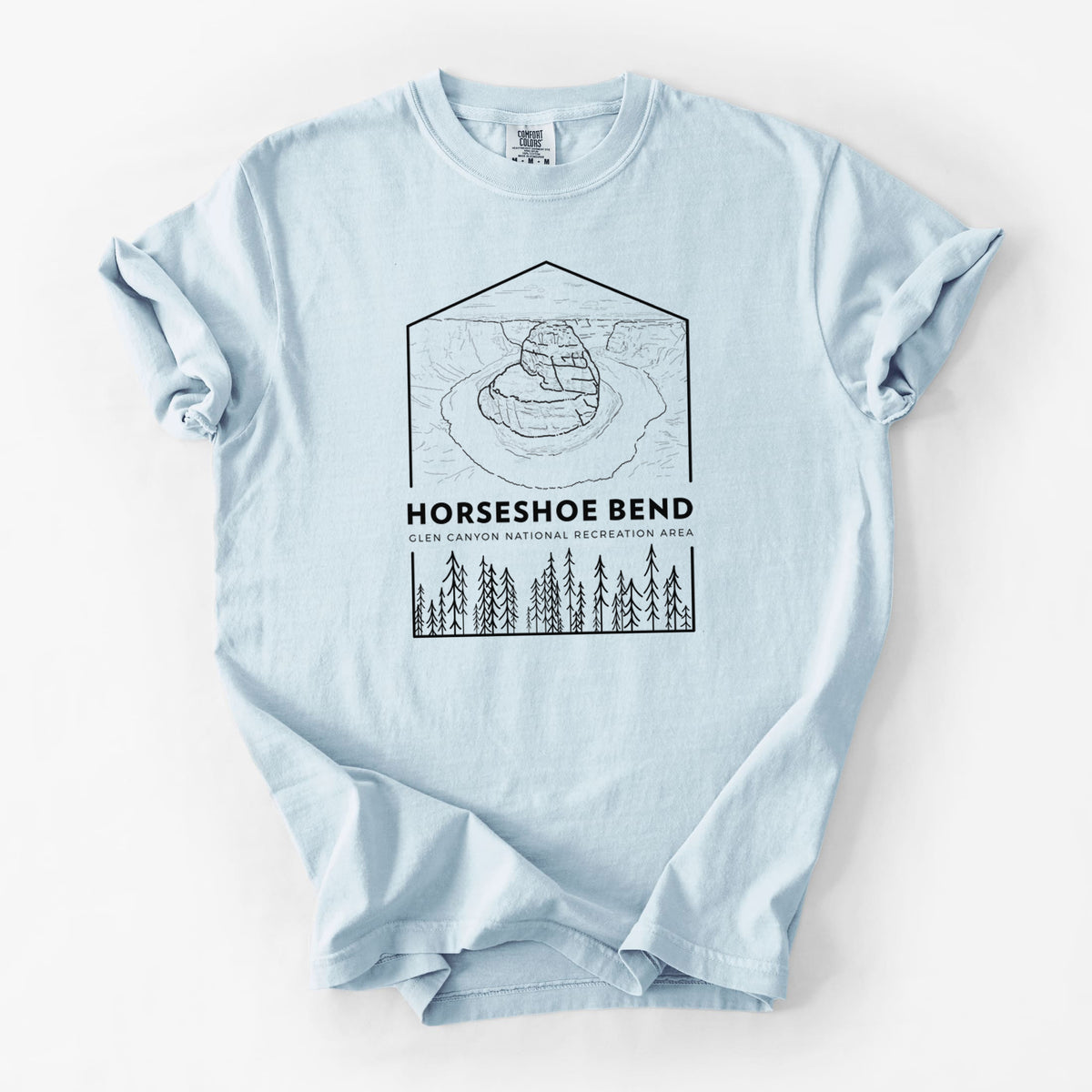 Chambray blue Comfort Colors t-shirt laid flat, printed with a black line art badge of Horseshoe Bend above pine trees, with the words Horseshoe Bend.