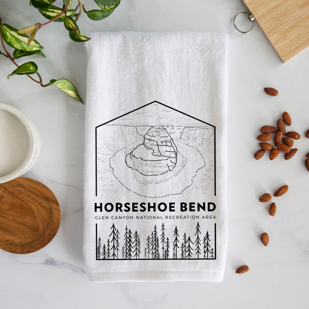 White hand towel printed with a black line art badge of Horseshoe Bend above pine trees, with the words Horseshoe Bend.