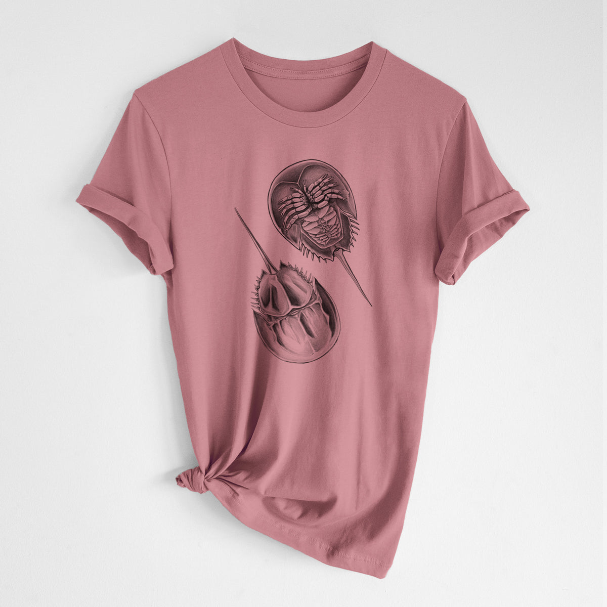 Mauve pink lightweight cotton t-shirt laid flat with the sleeves rolled, printed with a detailed black ink illustration of two horseshoe crabs.