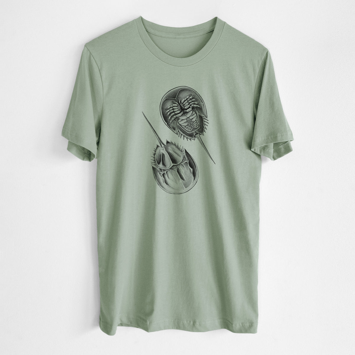Sage green lightweight cotton t-shirt laid flat, printed with a detailed black ink illustration of two horseshoe crabs.