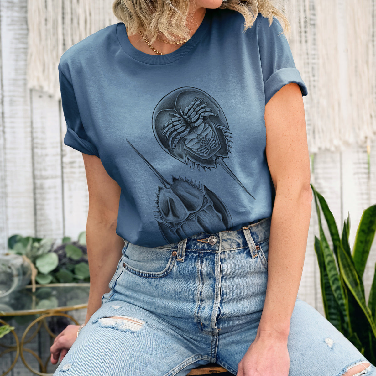 Woman wearing a steel blue lightweight cotton t-shirt printed with a detailed black ink illustration of two horseshoe crabs.