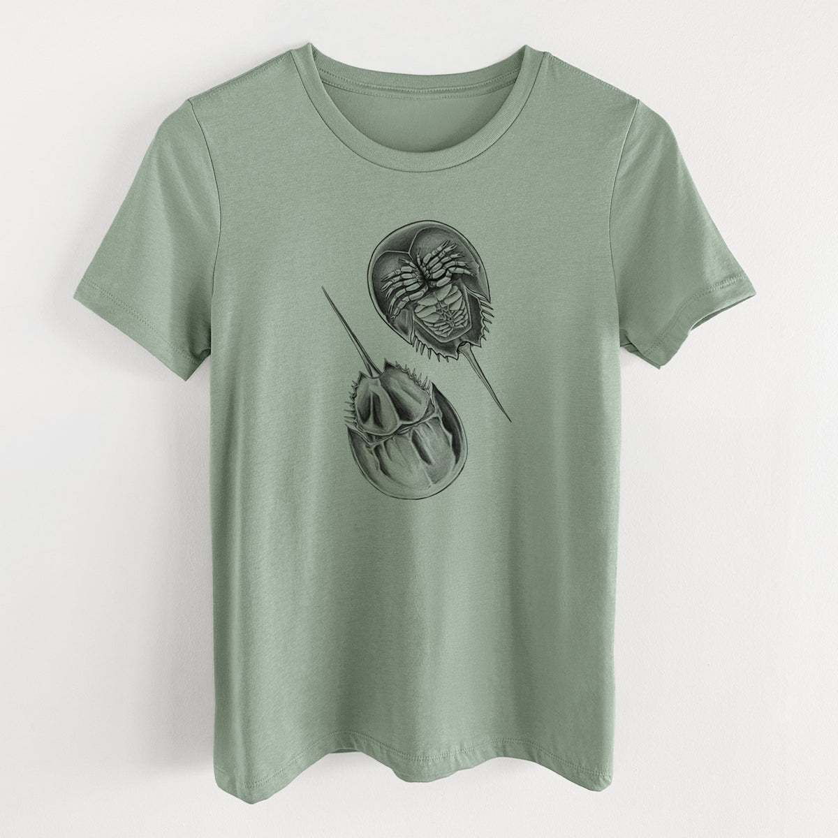 Sage green women's relaxed fit cotton t-shirt laid flat, printed with a detailed black ink illustration of two horseshoe crabs.