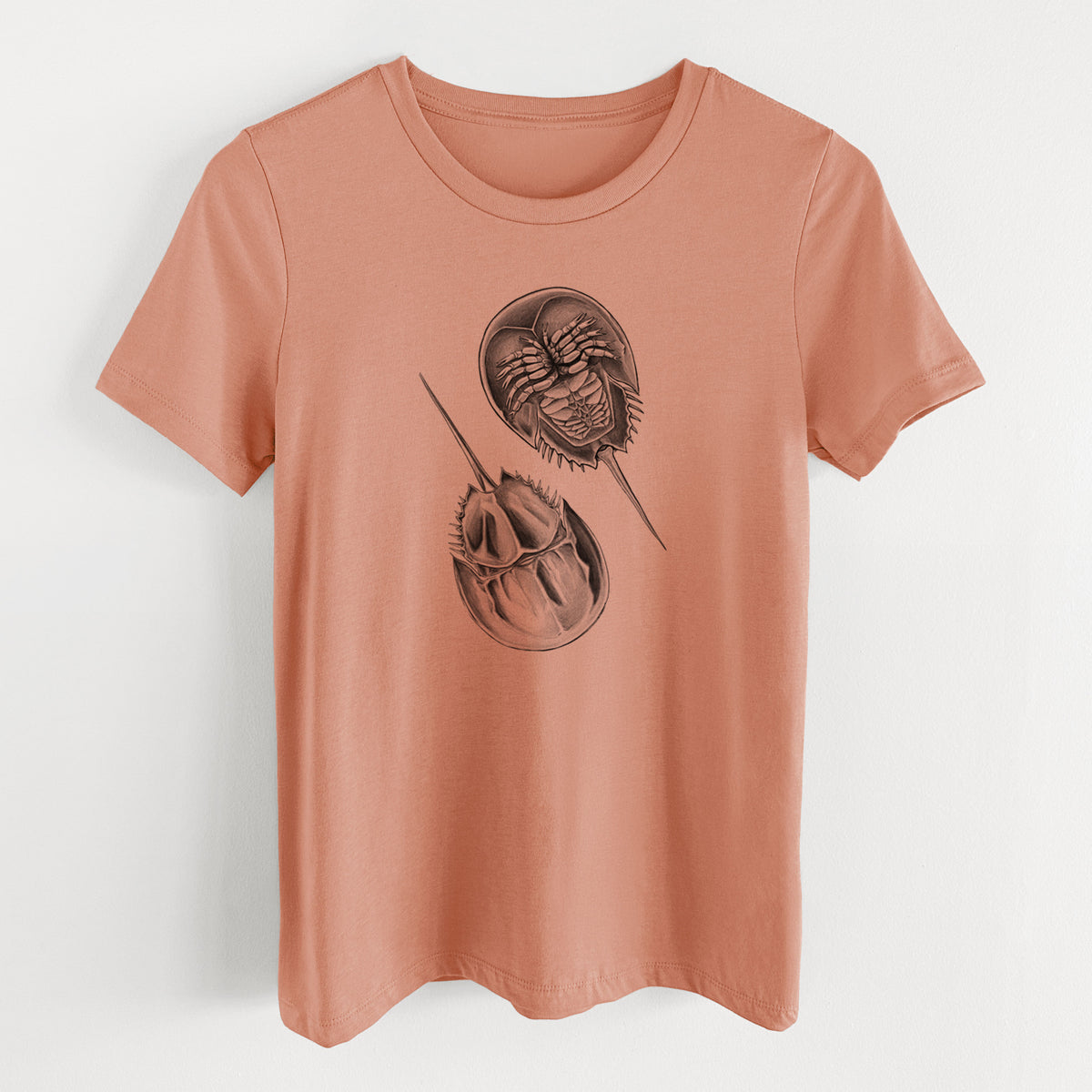 Terracotta orange women's relaxed fit cotton t-shirt laid flat, printed with a detailed black ink illustration of two horseshoe crabs.