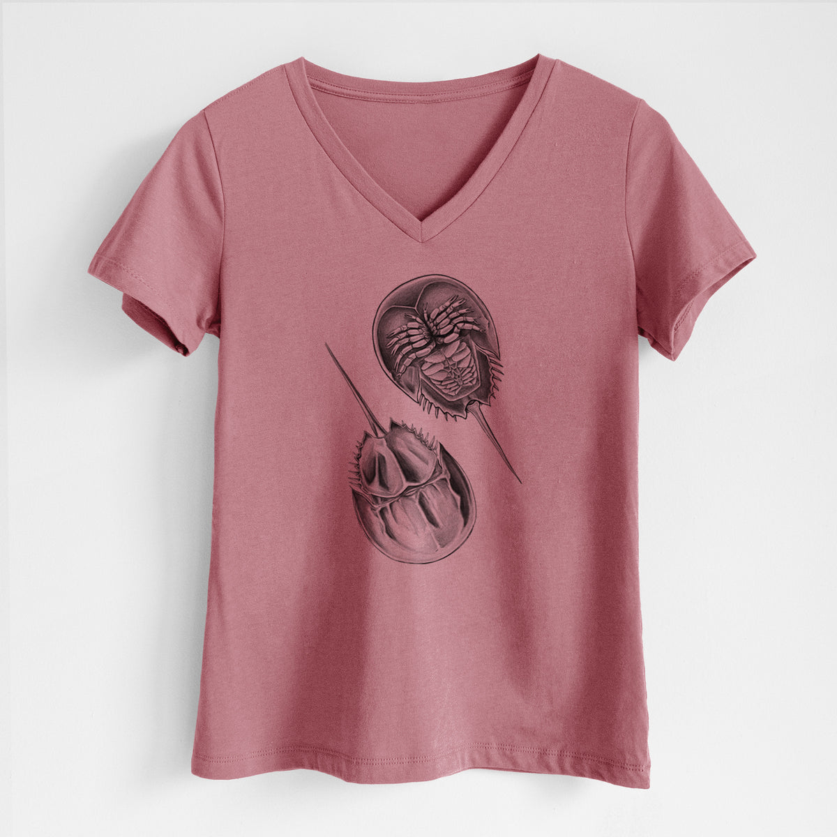 Mauve pink women's relaxed fit cotton V-neck t-shirt laid flat, printed with a detailed black ink illustration of two horseshoe crabs.
