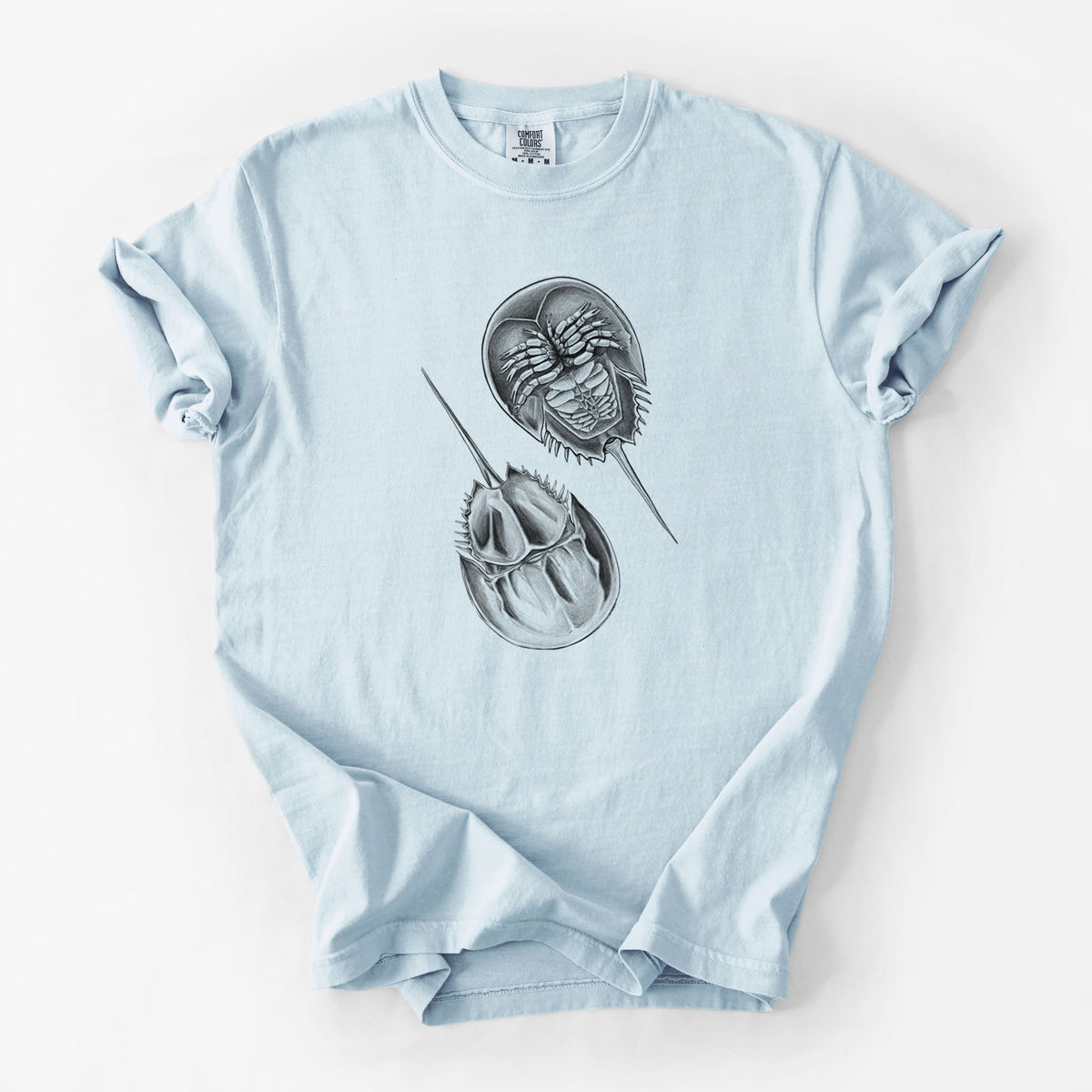 Chambray blue Comfort Colors t-shirt laid flat, printed with a detailed black ink illustration of two horseshoe crabs.