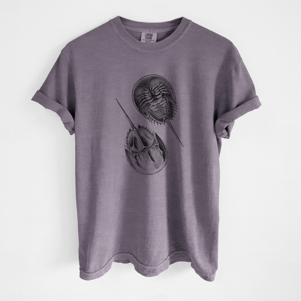 Wine red Comfort Colors t-shirt laid flat, printed with a detailed black ink illustration of two horseshoe crabs.