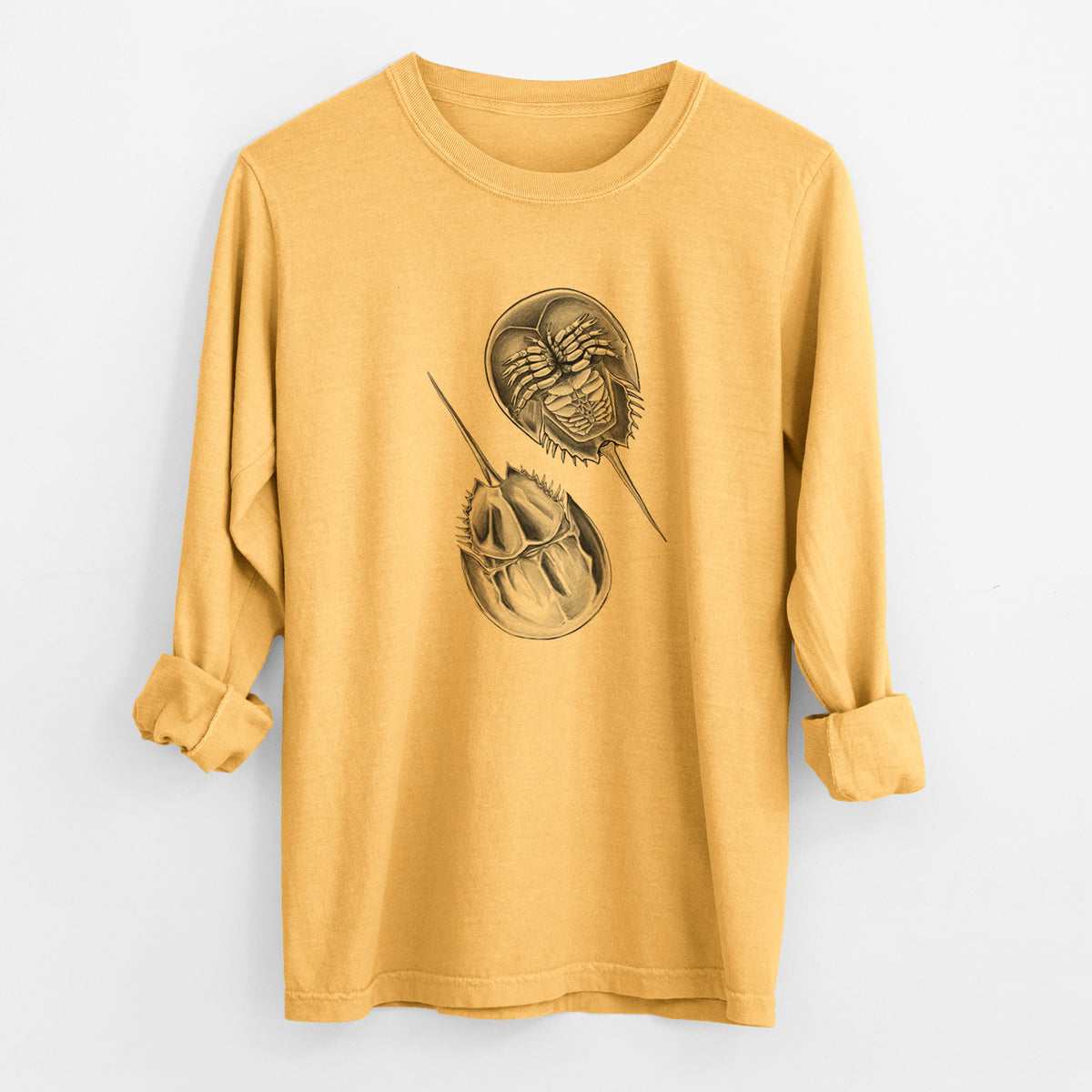 Golden wheat yellow Comfort Colors long sleeve shirt laid flat with the cuffs rolled, printed with a detailed black ink illustration of two horseshoe crabs.