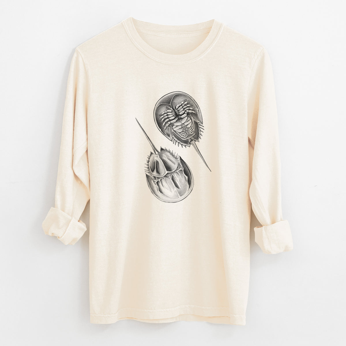 Ivory Comfort Colors long sleeve shirt laid flat with the cuffs rolled, printed with a detailed black ink illustration of two horseshoe crabs.