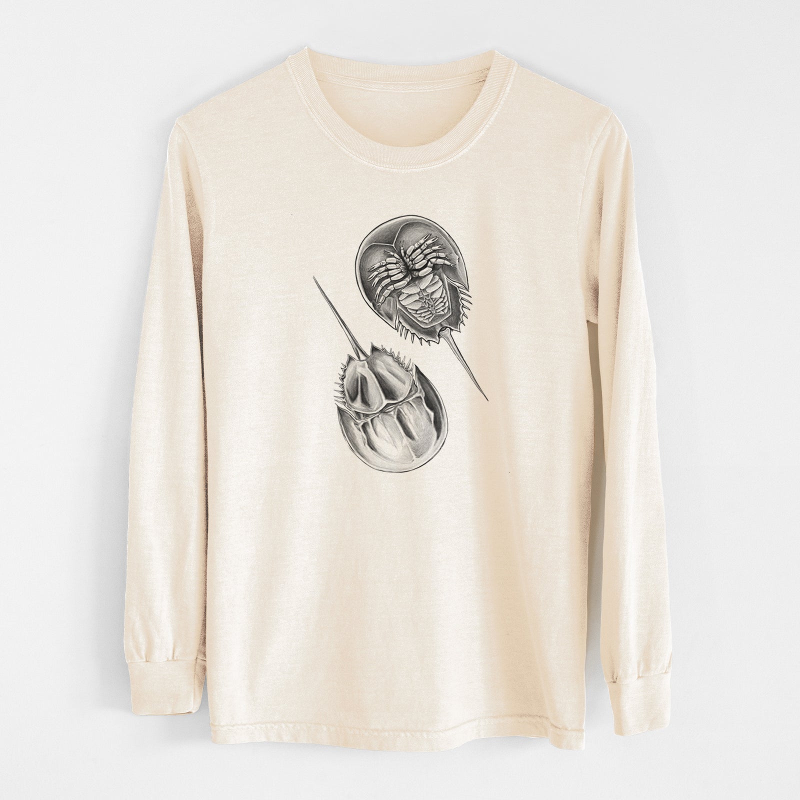 Ivory Comfort Colors long sleeve shirt laid flat, printed with a detailed black ink illustration of two horseshoe crabs.
