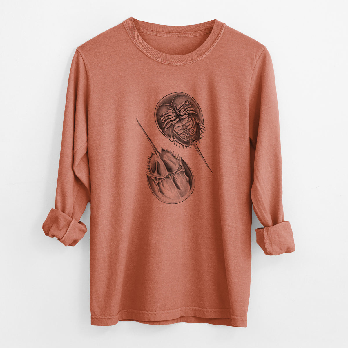 Yam burnt orange Comfort Colors long sleeve shirt laid flat with the cuffs rolled, printed with a detailed black ink illustration of two horseshoe crabs.