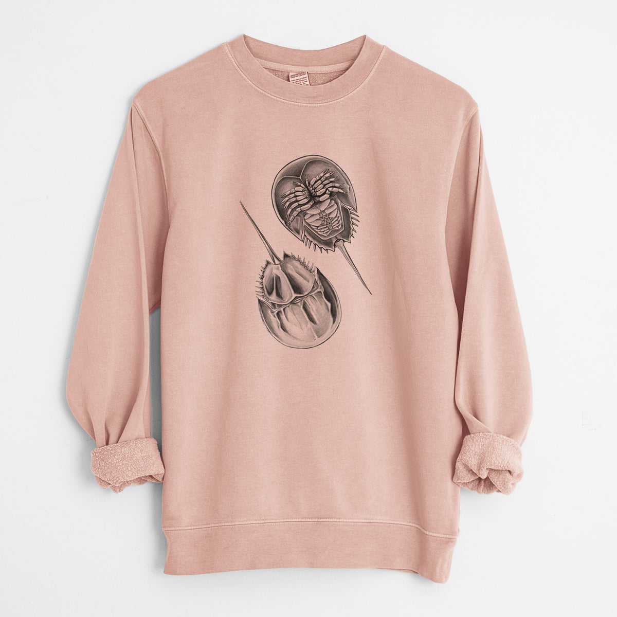 Dusty pink pigment dyed crewneck sweatshirt laid flat with the sleeves rolled, printed with a detailed black ink illustration of two horseshoe crabs.