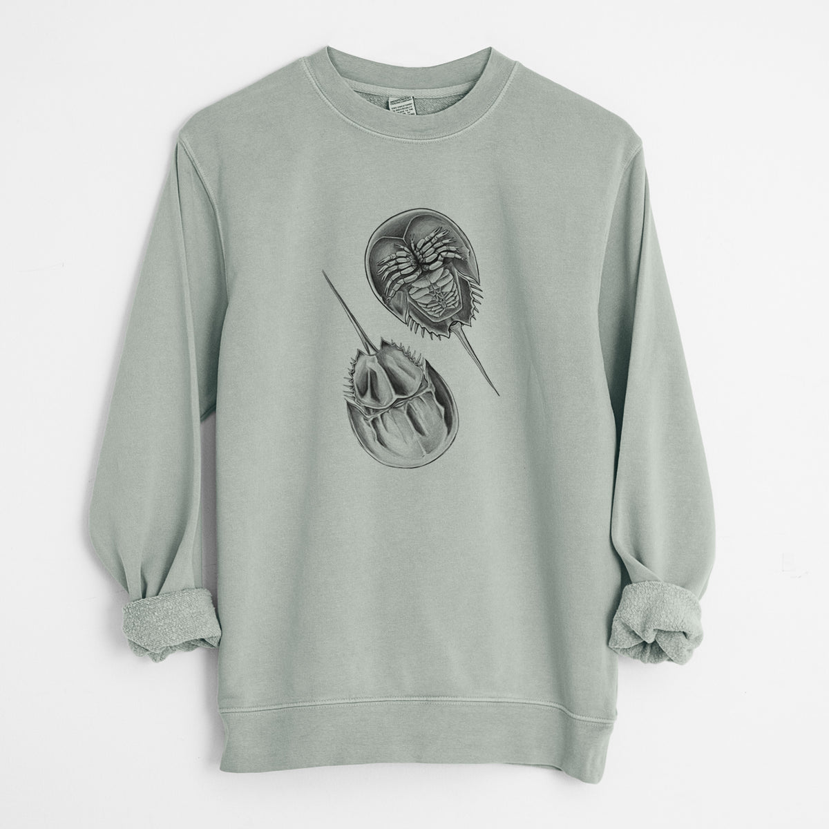 Sage green pigment dyed crewneck sweatshirt laid flat with the sleeves rolled, printed with a detailed black ink illustration of two horseshoe crabs.
