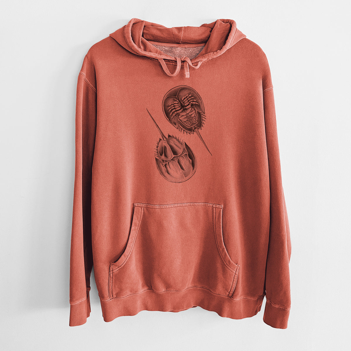 Amber orange pigment dyed hoodie laid flat, printed with a detailed black ink illustration of two horseshoe crabs.