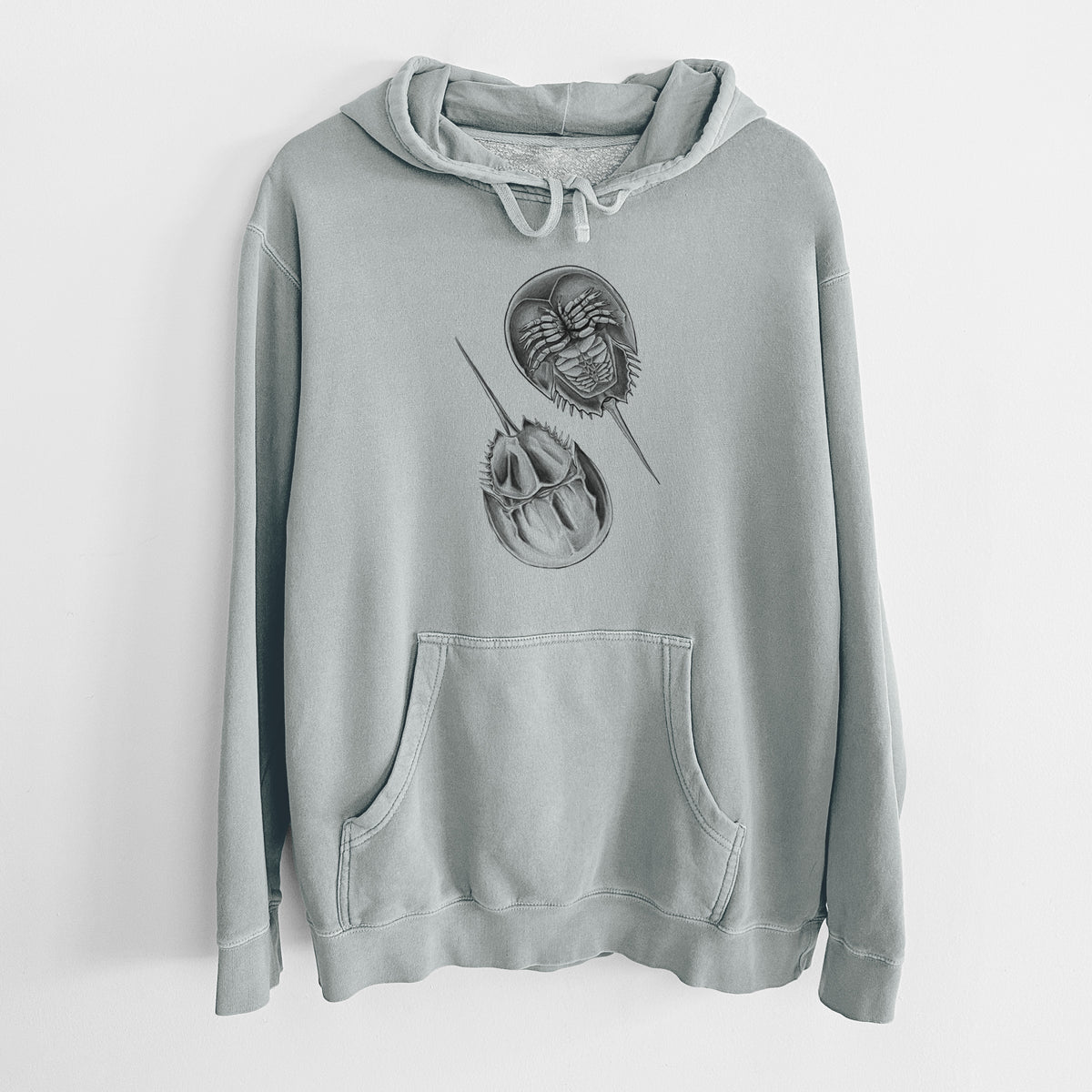 Sage green pigment dyed hoodie laid flat, printed with a detailed black ink illustration of two horseshoe crabs.