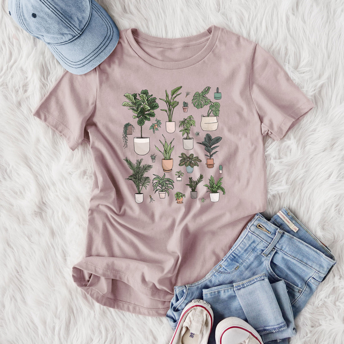Women's relaxed fit cotton t-shirt printed with a full-color collection of potted houseplants in different pots, styled flat on a white faux fur rug with jeans.