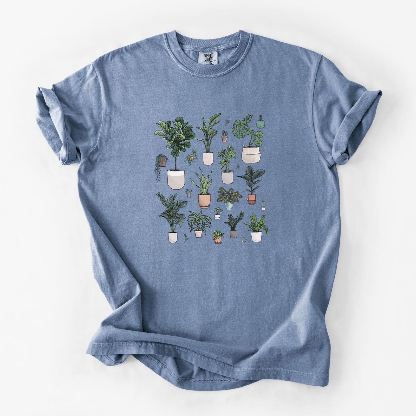 Blue jean Comfort Colors t-shirt laid flat, printed with a full-color collection of potted houseplants in different pots.