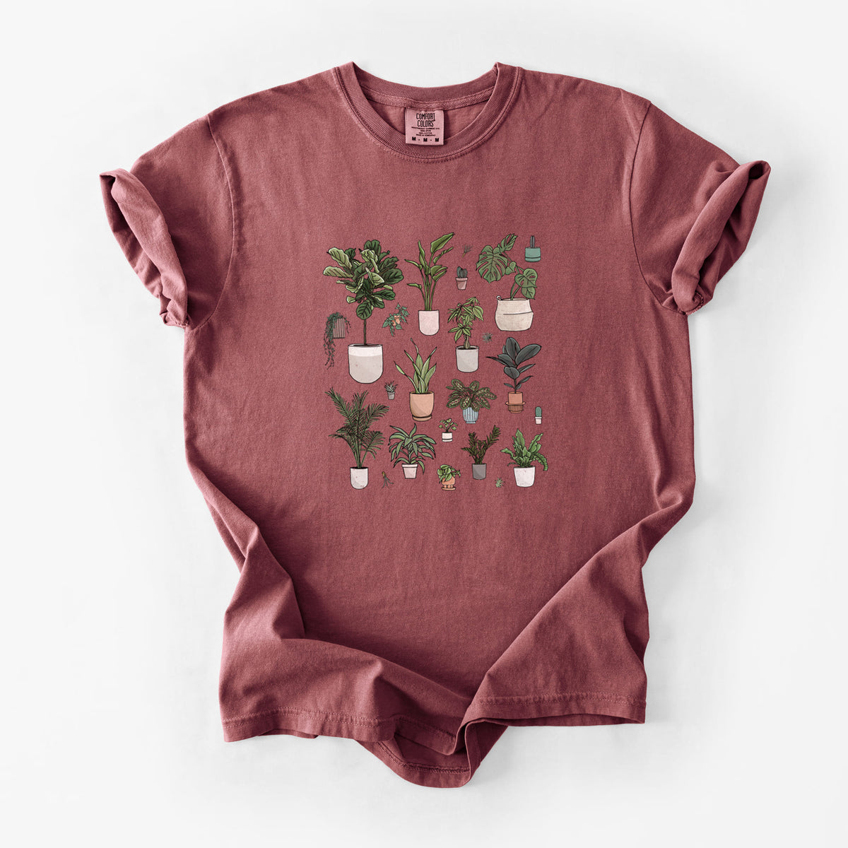 Brick red Comfort Colors t-shirt laid flat, printed with a full-color collection of potted houseplants in different pots.