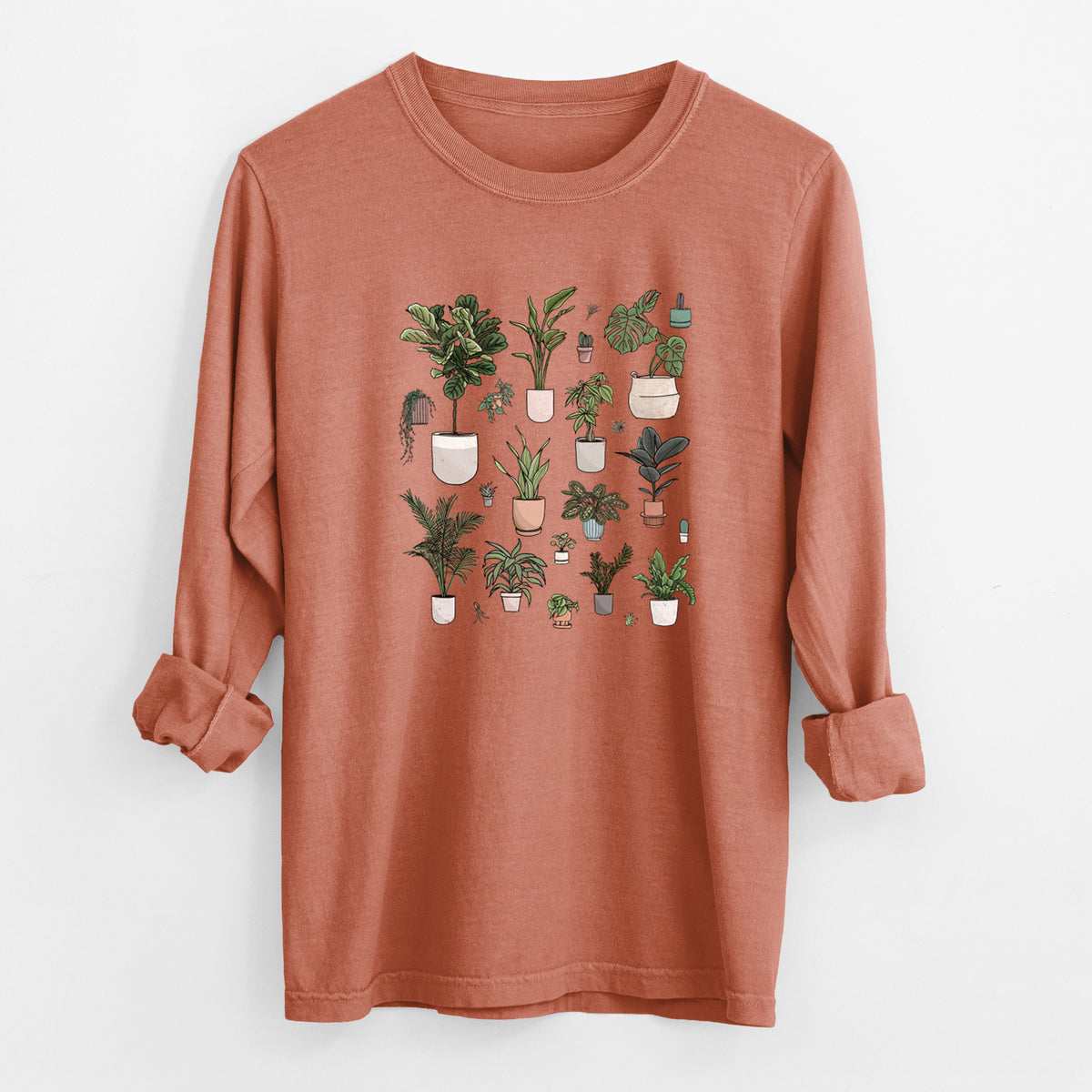 Yam burnt orange Comfort Colors long sleeve shirt laid flat with the cuffs rolled, printed with a full-color collection of potted houseplants in different pots.