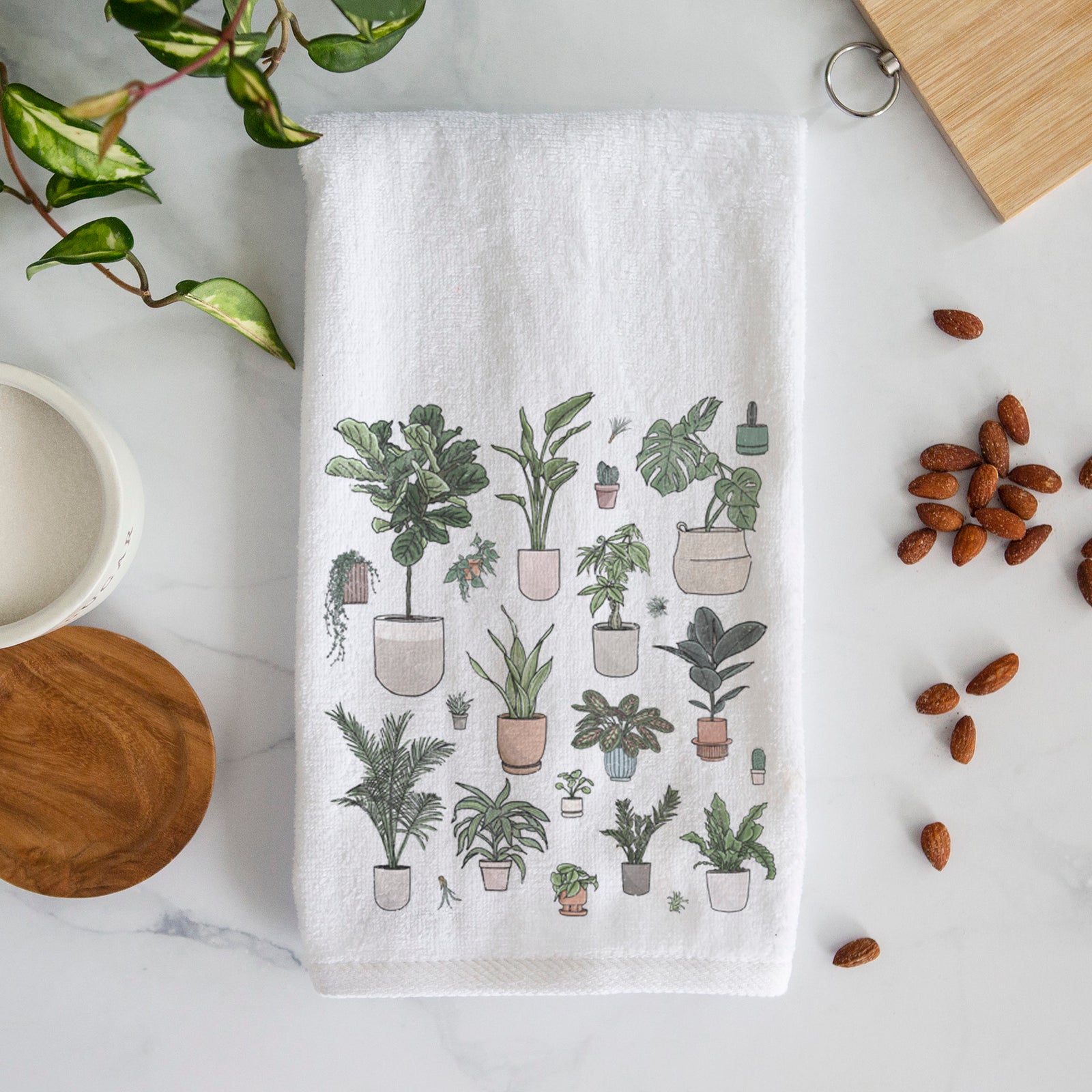 White hand towel printed with a full-color collection of potted houseplants in different pots.