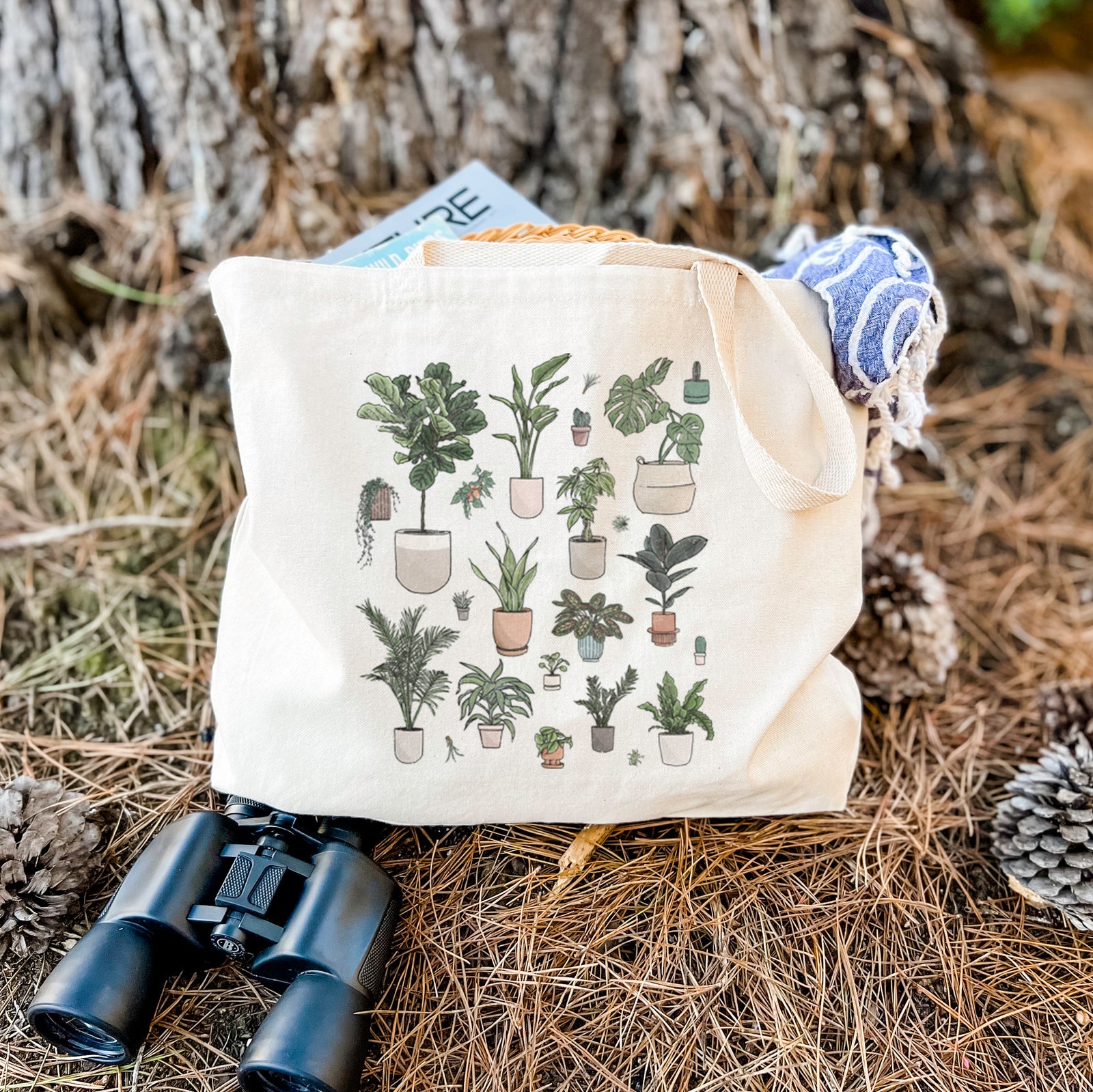 Natural canvas tote bag printed with a full-color collection of potted houseplants in different pots.