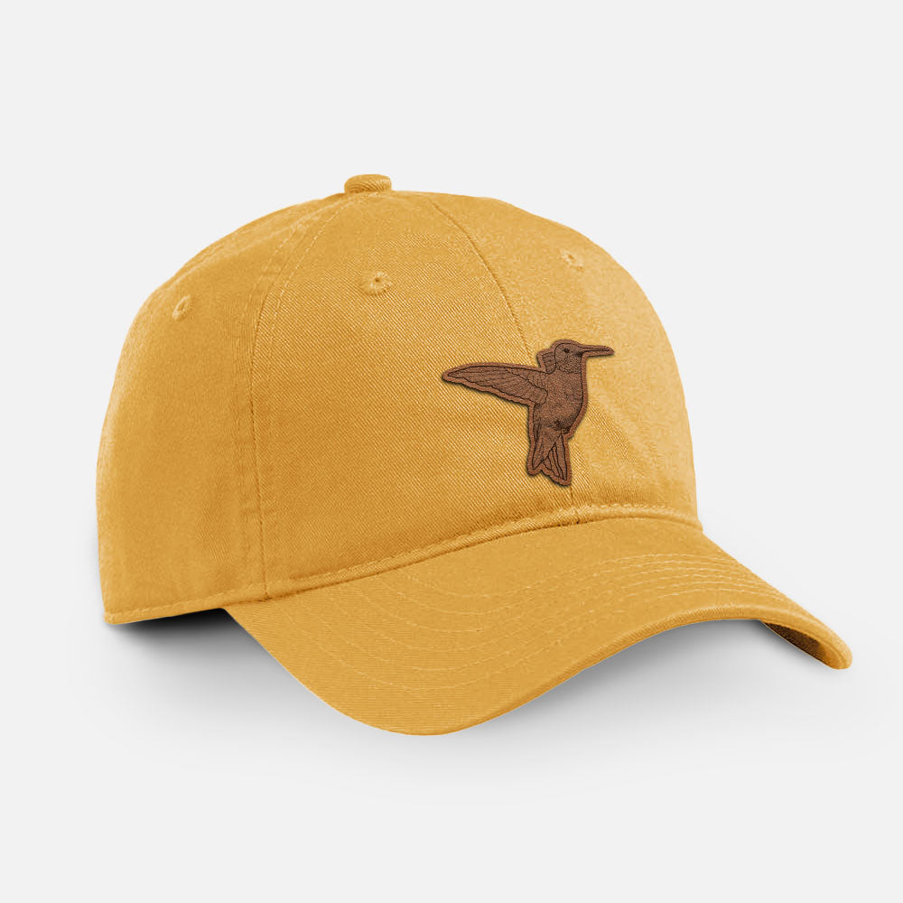 Beehive yellow cotton baseball hat with a detailed engraving of a hummingbird in flight on the front.