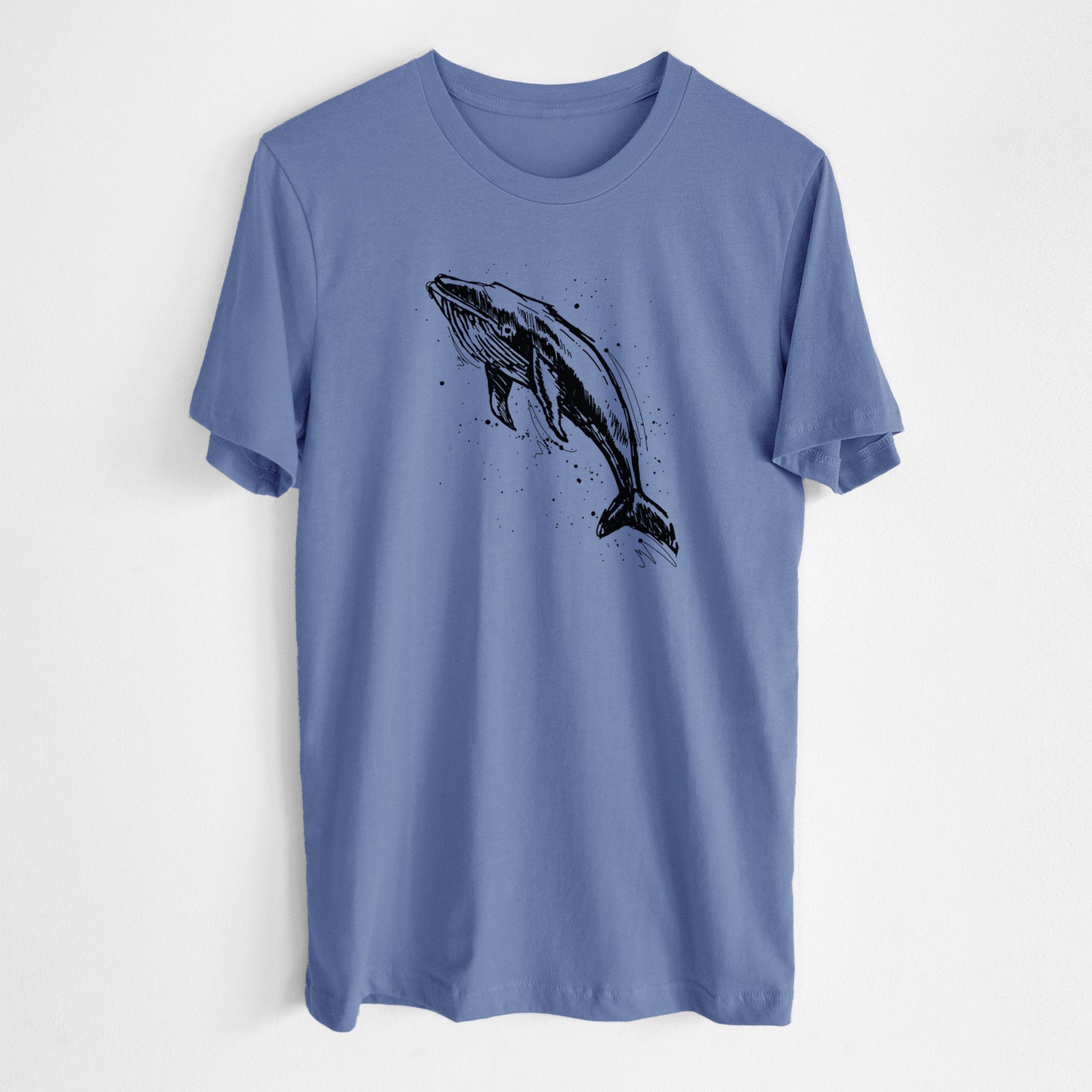 Blue bell lightweight cotton t-shirt laid flat, printed with a black ink illustration of a humpback whale diving, with ink splatters.