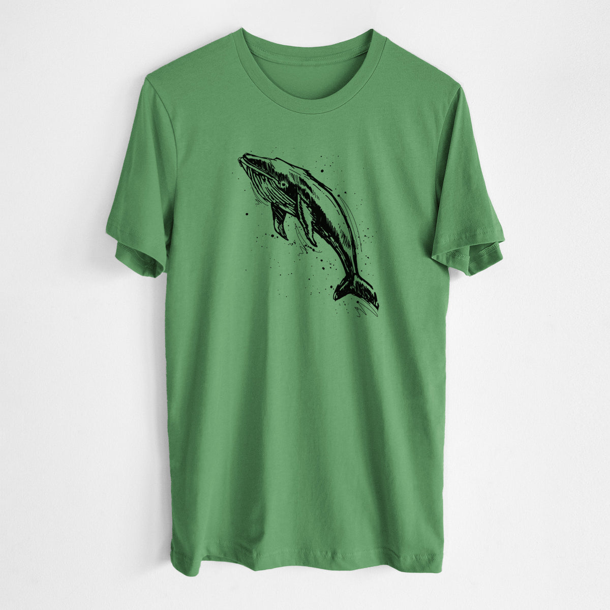 Leaf green lightweight cotton t-shirt laid flat, printed with a black ink illustration of a humpback whale diving, with ink splatters.