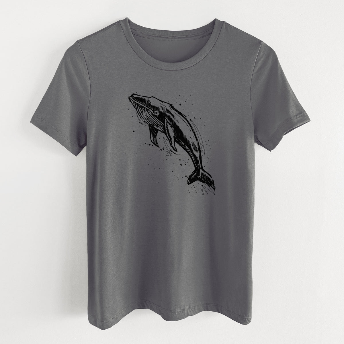 Asphalt women's relaxed fit cotton t-shirt laid flat, printed with a black ink illustration of a humpback whale diving, with ink splatters.